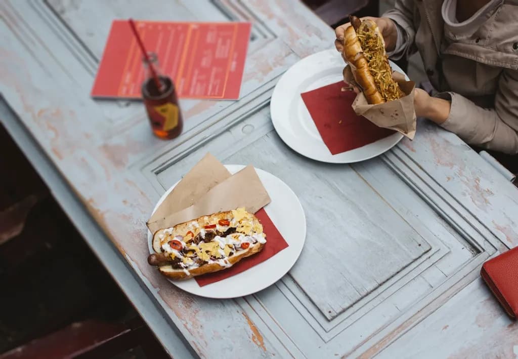 Perro Gratinado: Perro cargado con maíz tierno, tocineta y una capa generosa de mozzarella gratin